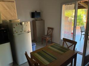 a kitchen with a table and a refrigerator and a table and chairs at Résidence Sofia Lynda in Le Plan-de-la-Tour