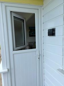 a white door with a window in a house at Sally Chalet in Hemsby +3 photos