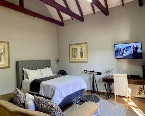 a bedroom with a bed and a tv on the wall at CView Suites & Apartments in Pretoria