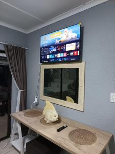 a room with a table with a tv on the wall at Summer Place 12 in Shelly Beach +16 photos