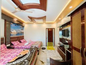 a bedroom with two beds and a flat screen tv at Lokenath Resort in Tarapith