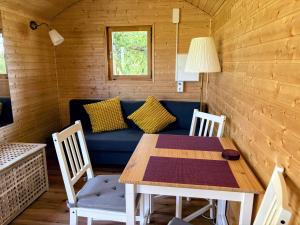 a dining room with a blue couch and a table at Sonnenhof Uckermark in Lübbenow