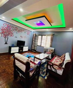 a living room with a large tv on the ceiling at Sumitra Niwas-Home Away from Home in Bālāju
