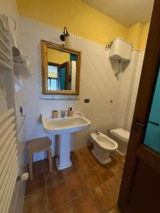 a bathroom with a sink and a toilet and a mirror at Il Ritrovo degli Angeli in San Mauro Cilento +37 photos