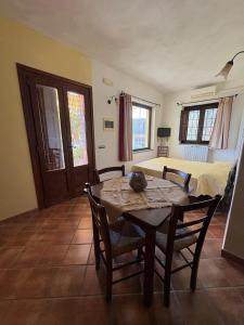 a room with a table and chairs and a bed at Il Ritrovo degli Angeli in San Mauro Cilento