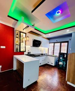 a kitchen with a white counter and green lights at Sumitra Niwas-Home Away from Home in Bālāju