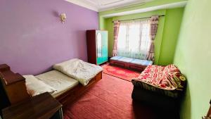 a small room with two beds and a window at Sumitra Niwas-Home Away from Home in Bālāju