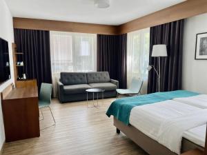 a hotel room with a bed and a couch at Hotel Raumanlinna in Rauma +17 photos
