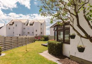 a white house with a fence and a yard at 9 Lodge Walk, Elie in Elie
