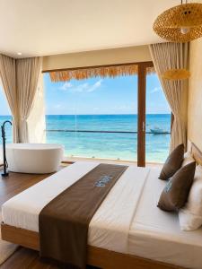 a bedroom with a large bed and a view of the ocean at Sala Beach Villa Phú Quý in Cù Lao Thu