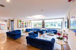 a large living room with blue couches and windows at AN Hotel Milano San Donato in San Donato Milanese