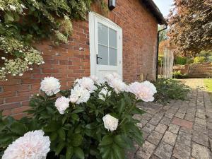 a bunch of pink flowers in front of a brick house at The Coach House in Halstead