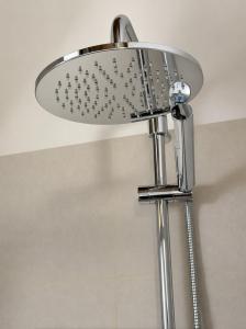 a shower head in a bathroom next to a wall at Agriturismo La Rasdora in Porto Mantovano