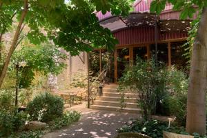 a garden with a house with stairs and trees at Platan in Samarkand