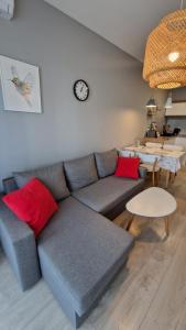 a living room with a blue couch and red pillows at Apartamenty Września in Września