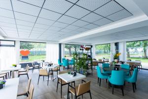 a restaurant with tables and chairs and blue chairs at AN Hotel Milano San Donato in San Donato Milanese +44 photos