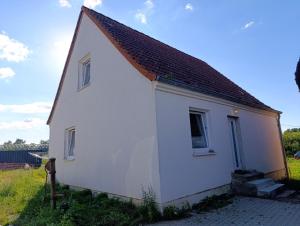 a small white house with a red roof at Landhaus Leopold in Sanitz