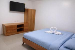 a bedroom with a bed with two white towels at Angelito's Beach House Siargao near Beach in General Luna