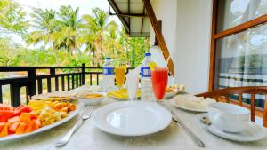 a table with plates of food and drinks on it at Akash Treehouse in Sigiriya