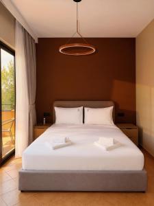 a bedroom with a bed with two white towels on it at Azel Boutique Hotel in Draç