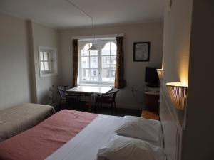 een slaapkamer met een bed, een tafel en een raam bij Logies De Wandelaar in Middelkerke