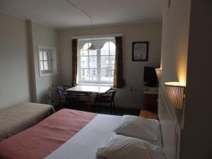 a bedroom with a bed and a table and a window at Logies De Wandelaar in Middelkerke