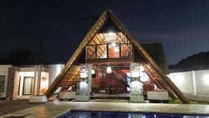 a house with a triangular roof with a pool at Tiptree Lodge in Livingstone