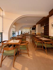 an empty restaurant with wooden tables and chairs at Azel Boutique Hotel in Draç