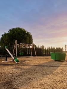 a playground with a swing set in the sand at Azel Boutique Hotel in Draç