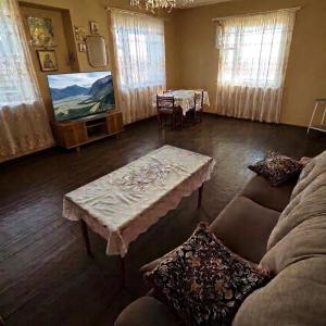 a living room with a couch and a table at Antarut Garden House in Antarut