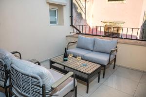 a balcony with a couch and a table and chairs at Lasa Pur Dir in Piran
