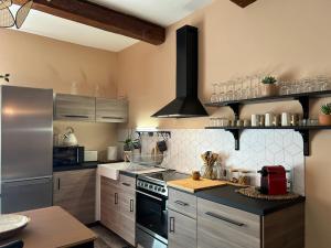 a kitchen with a stove and a refrigerator at MAISON la BOHÈME Une parenthèse enchantée au cœur du charme, petit-déjeuner de rêve in Vias