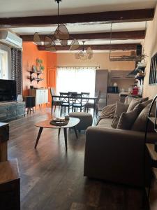 a living room with a couch and a table at MAISON la BOHÈME Une parenthèse enchantée au cœur du charme, petit-déjeuner de rêve in Vias