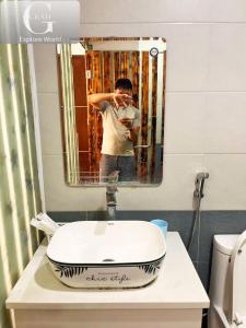 a man taking a picture of himself in a bathroom mirror at Hanoi Gold Hotel Near Bach Mai in Hanoi +34 photos