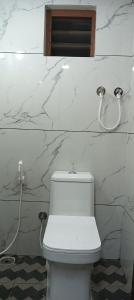 a white toilet in a bathroom with marble walls at Mount Star Home Stay in Kakkabe