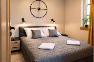 a bedroom with a large bed with two towels on it at Ewilla- apartamenty Wojcieszyce in Wojcieszyce