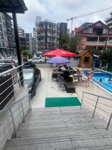 a swimming pool with a table and chairs and an umbrella at White Room in Gonio