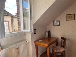 a room with a wooden table and a window at Chez Merlin le brocanteur in Charny