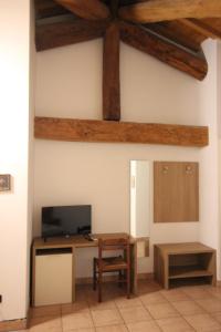 a room with a desk and a tv on a wall at Agriturismo La Rasdora in Porto Mantovano