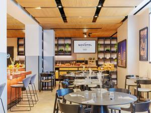 a restaurant with tables and chairs and a bar at Novotel Parma Centro in Parma