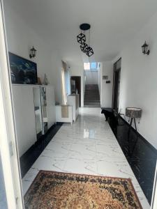 a hallway with white walls and a rug on the floor at White Room in Gonio