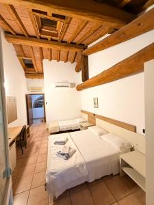 two beds in a room with wooden ceilings at Agriturismo La Rasdora in Porto Mantovano