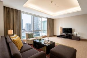 a living room with a couch and a tv at Ascott Sathorn Bangkok in Bangkok