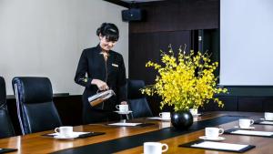 a woman in a suit standing over a table at Ascott Sathorn Bangkok in Bangkok +48 photos