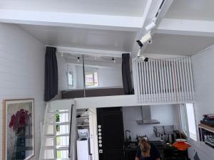 a woman sitting in a room with a white staircase at Harbor Breeze & Garden Peace in Åhus
