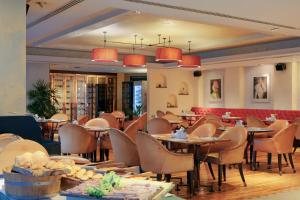 a restaurant with tables and chairs in a room at Ascott Sathorn Bangkok in Bangkok