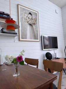 a dining room with a table with a vase of flowers at Harbor Breeze & Garden Peace in Åhus