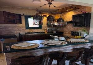 a kitchen with a counter with chairs and a table at Luxury Chalet - La Hacienda in Ras Sedr