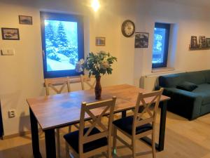 a dining room table and chairs with a vase with flowers at Apartmán Albrechtice 97 in Albrechtice v Jizerských horách +12 photos