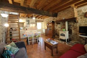 a living room with a table and a fireplace at Mounismes du bas in Saint-Ouen-sur-Gartempe